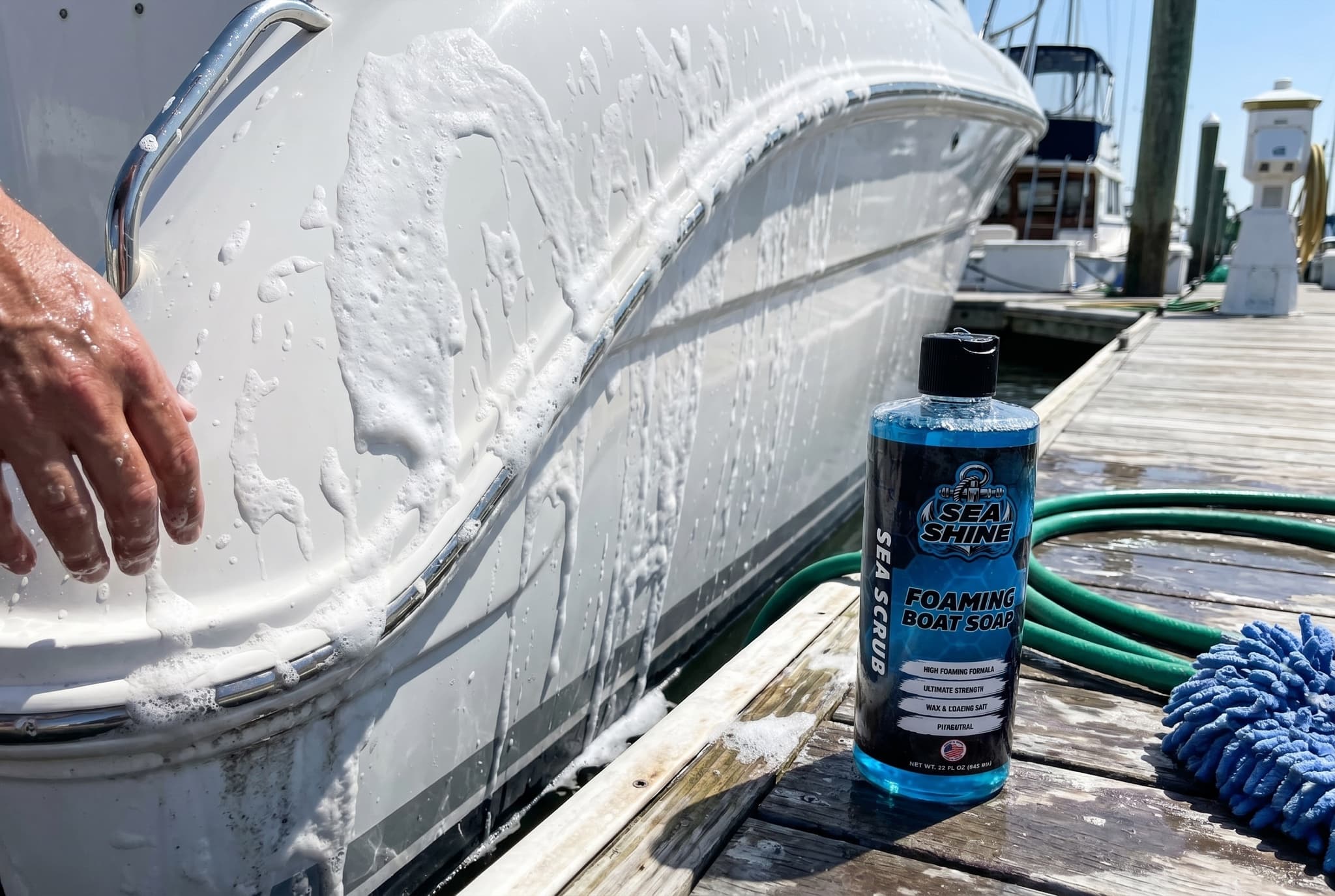 Thick Sea Scrub foam clinging to a boat hull mid-wash